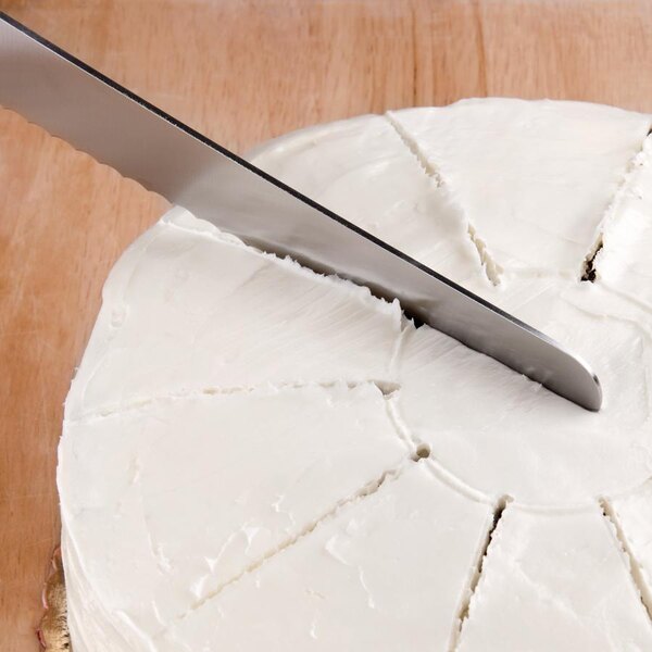 A knife cutting a cake with an Ateco Double-Sided Cake Marker.