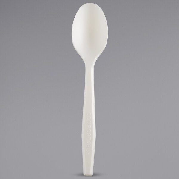 a white plastic spoon on a gray surface