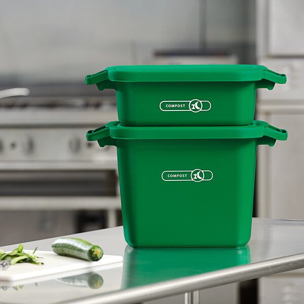 Two green Rubbermaid compost bins on a table.