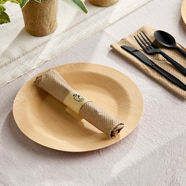 A black napkin with a Fineline black spoon and fork on a plate.