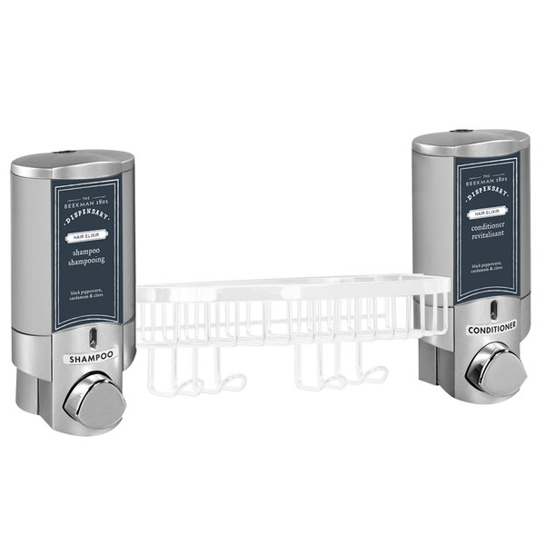 A wall-mounted Aviva soap dispenser with two satin silver bottles and a white basket with Beekman logo.