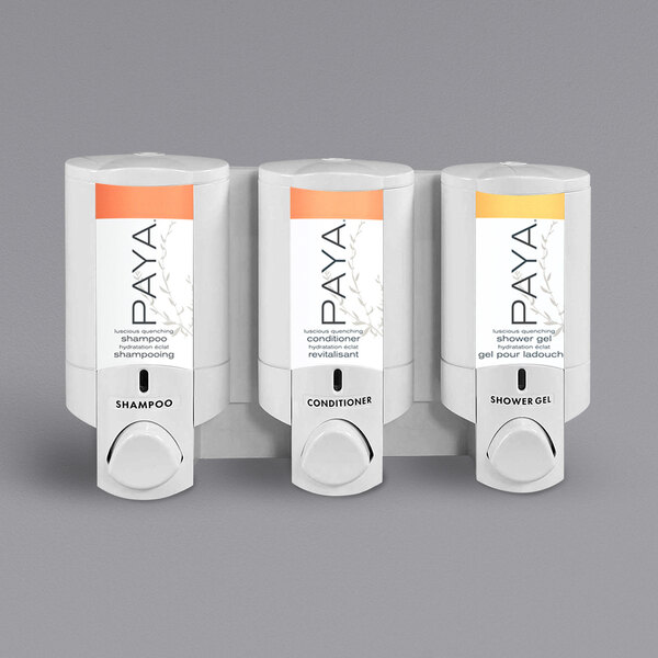 Three white Dispenser Amenities bottles with black Paya labels.