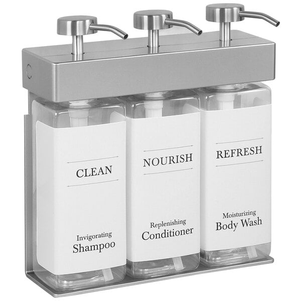 A white Dispenser Amenities wall-mounted shower dispenser with three rectangular bottles.