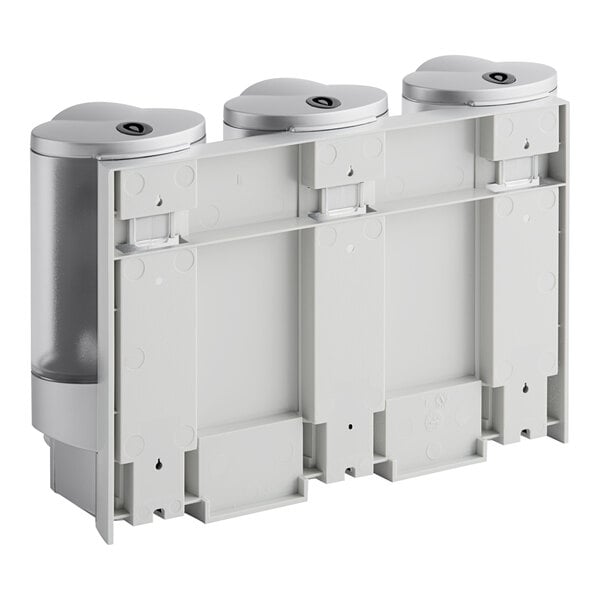 A three-chamber wall mounted satin silver soap dispenser with translucent bottles and locking lids.