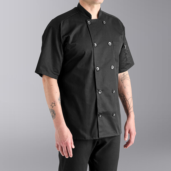 A man wearing a black Uncommon Chef short sleeve chef coat.