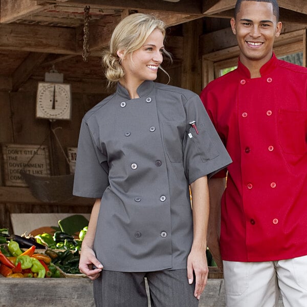 A man and woman wearing Uncommon Chef short sleeve chef coats in a kitchen.