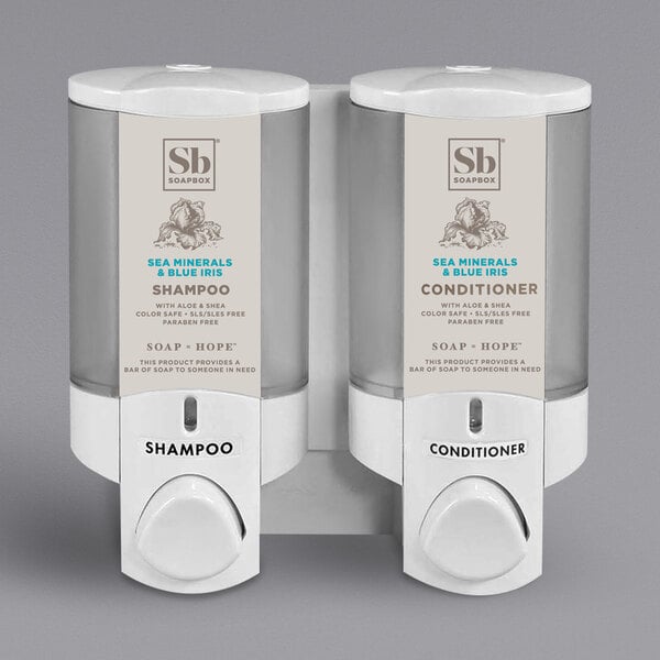 A white Dispenser Amenities Aviva 2-chamber wall mounted soap dispenser with translucent bottles.