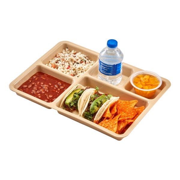 A beige compartment tray containing rice, beans, three tacos, tortilla chips, a cup of fruit, and a bottle of water.