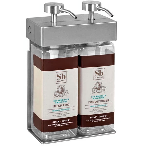 A white ABS plastic wall-mounted dispenser with two rectangular bottles. One bottle has a brown label and the other has a white label.