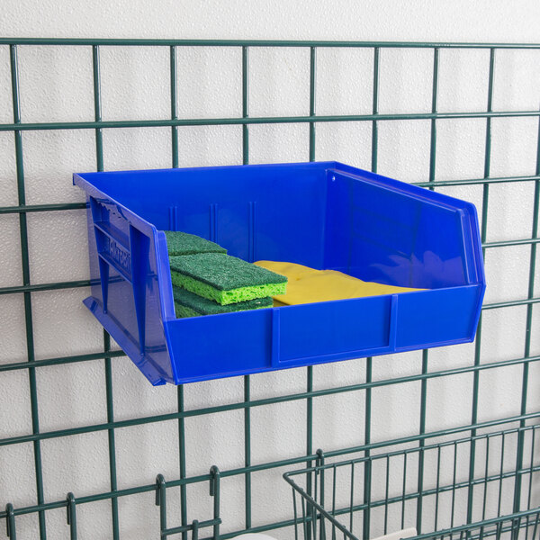 A blue Metro stack bin with sponges inside.
