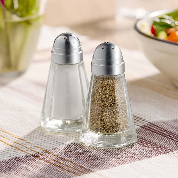 Two American Metalcraft salt and pepper shakers on a table.