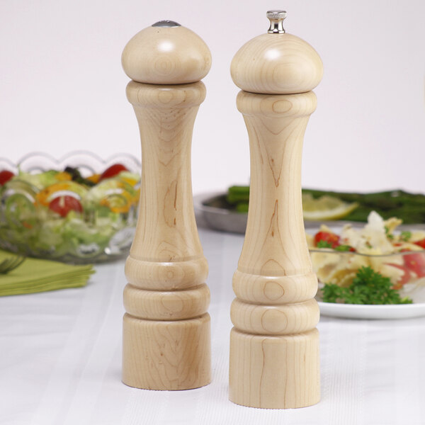 Two wooden Chef Specialties pepper mills on a table.