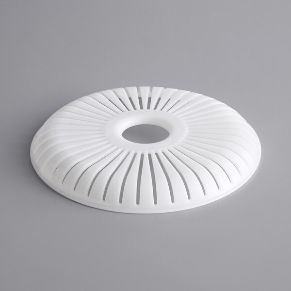 A white circular strainer for a Hamilton Beach juicer with holes in it.