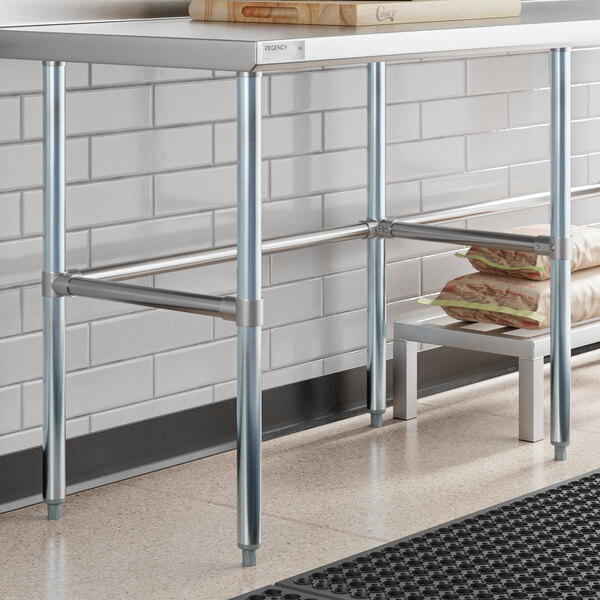 A Regency stainless steel work table with a shelf holding food bags.