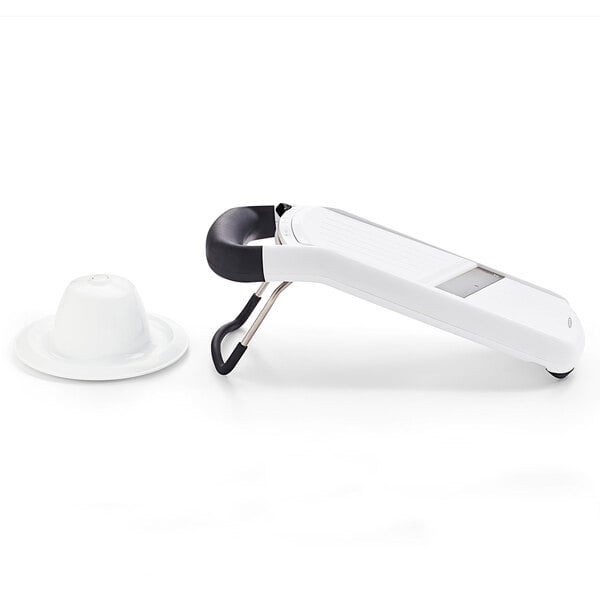 An OXO white plastic mandoline slicer with a white cover.