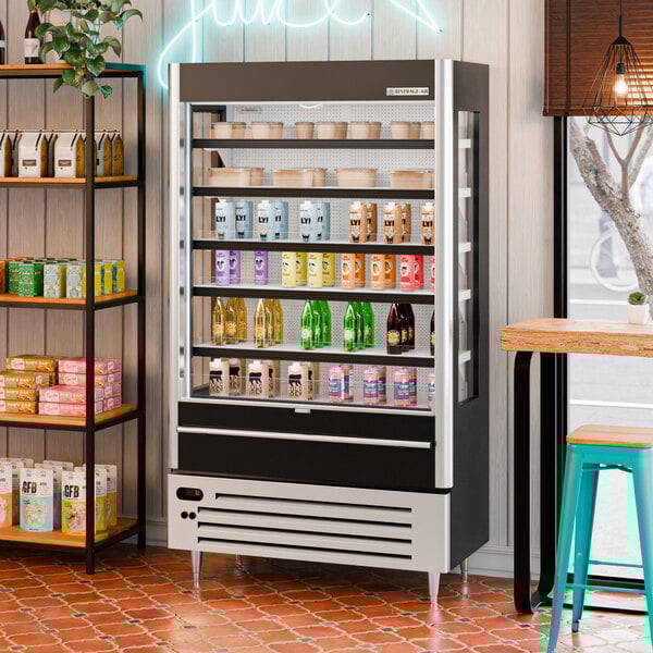 A black and silver open-air curtain merchandiser refrigerator displaying various drinks and food containers.