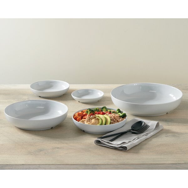 An American Metalcraft white melamine bowl on a table with food.