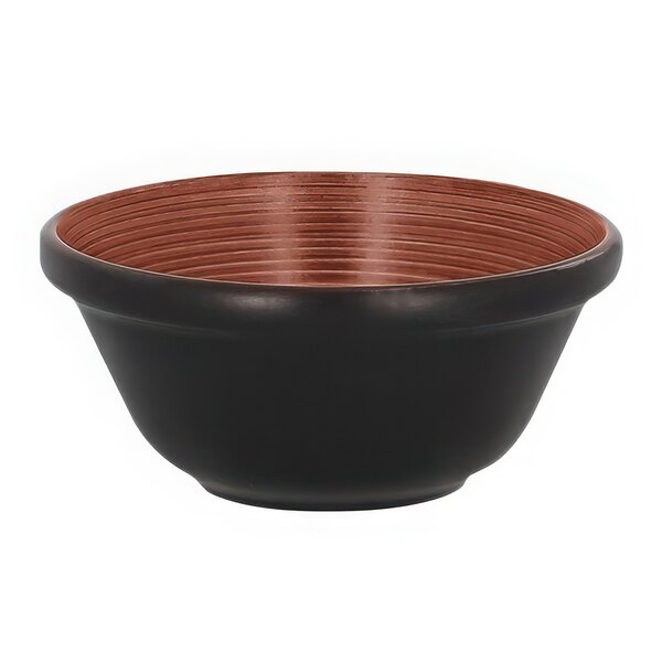 A black bowl with a brown rim made of copper.