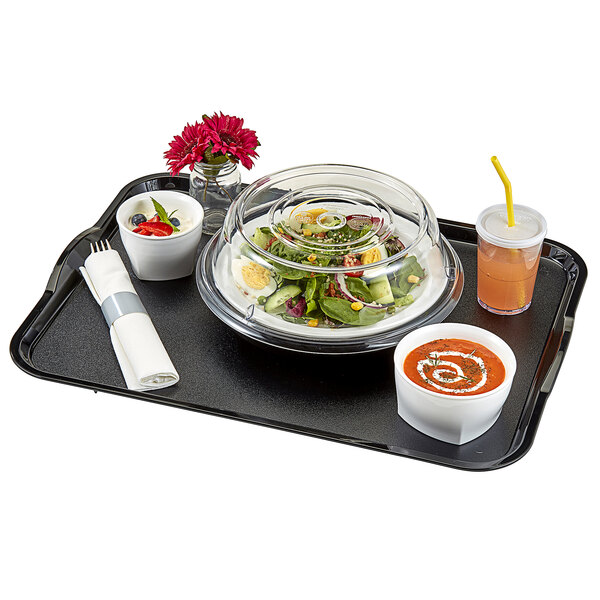 A tray with a salad and a bowl of soup, both in white plastic bowls with a silver band on the napkin.