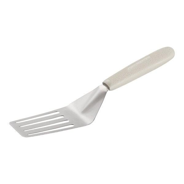 A metal slotted turner with a white textured handle.