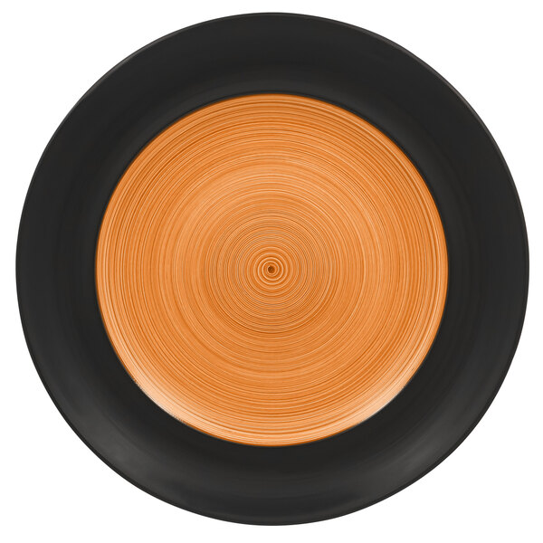 A close up of a RAK Porcelain Trinidad wide rim porcelain plate with a black and orange circular design.