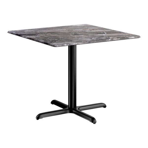 A square standard height table with a smooth dark finish and a black cross base plate.