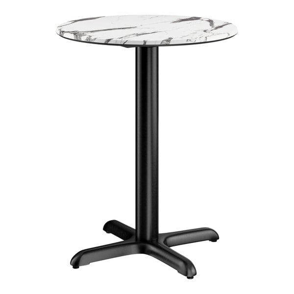 A round table with a smooth white and gray marble-like top and a black metal cross base.