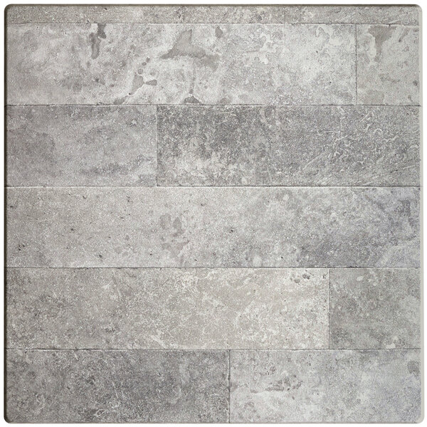 A close-up of a Lancaster Table & Seating square table with a textured gray tile top.