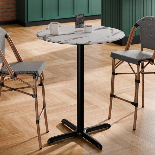 A round bar height table with a smooth Versilla finish and a black cross base plate.