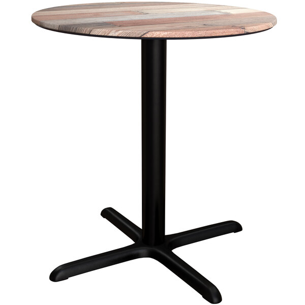 A Lancaster Table & Seating round dining table with a black cross base and wooden top.
