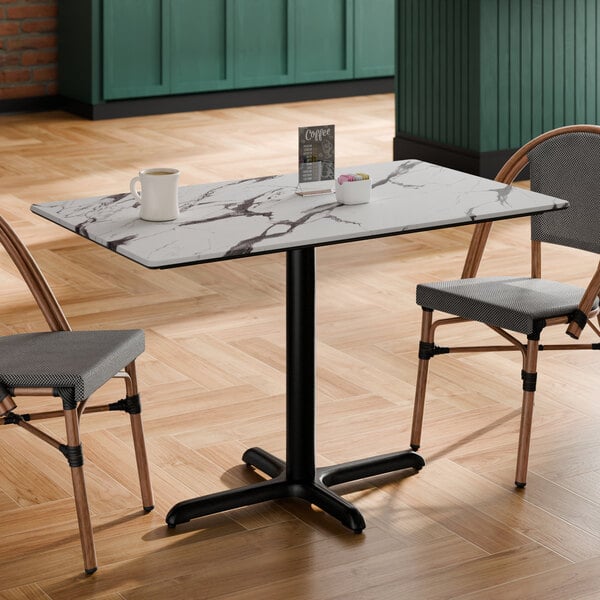 A rectangular standard height table with a smooth Versilla finish and a black cross base plate.