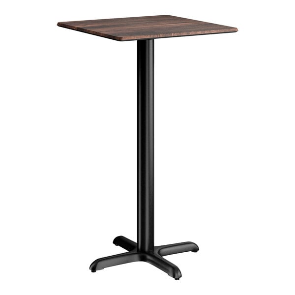 A square bar height table with a textured walnut finish top and a black cross base plate.