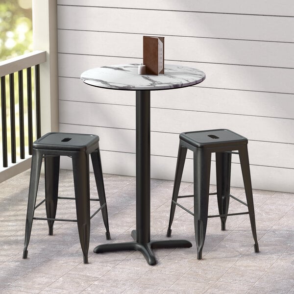 A Lancaster Table & Seating round table with a smooth marble top and cross base plate.