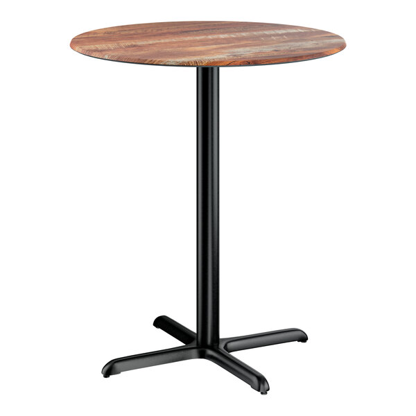 A round bar height table with a textured Yukon oak finish top and a black cross base plate.
