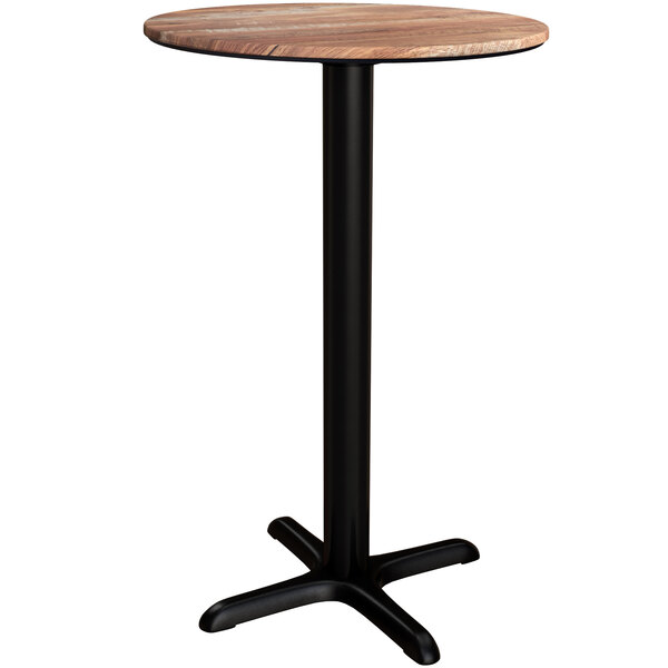 A Lancaster Table & Seating round counter height table with a textured Yukon oak finish and black cross base.