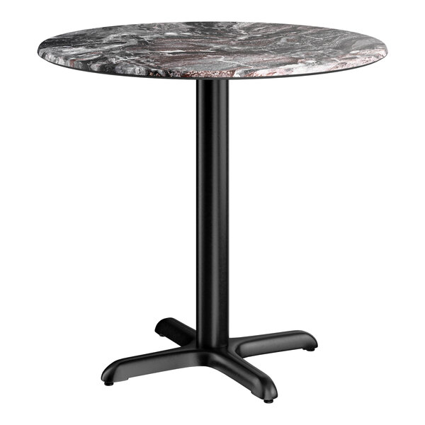 A round standard height table with a smooth paladina finish top and a black cross base plate.