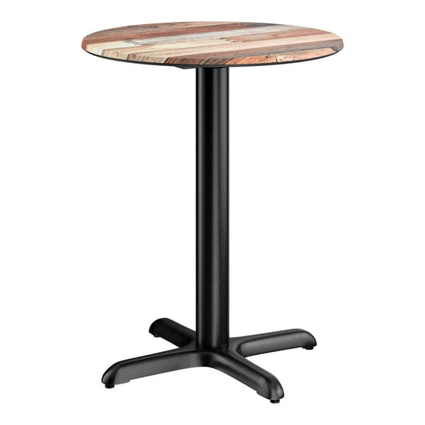 A round standard height table with a textured mixed plank finish top and a black cross base plate.
