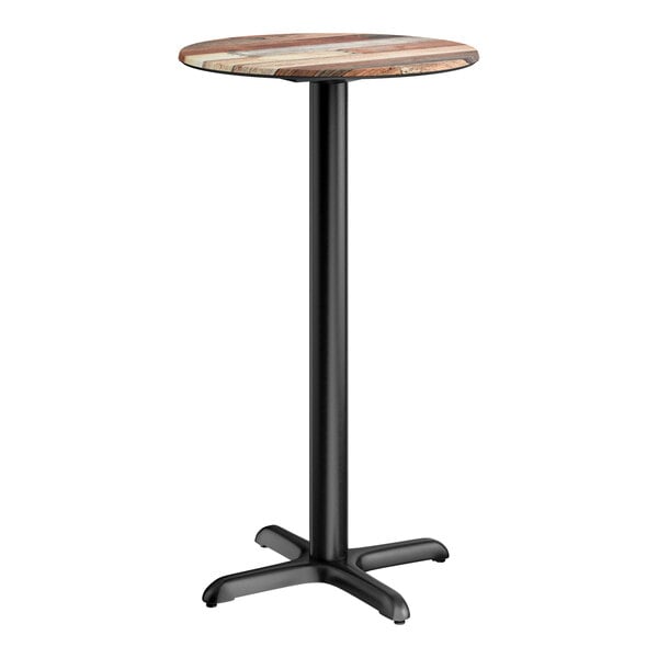 A round bar height table with a textured mixed plank finish top and a black cross base plate.