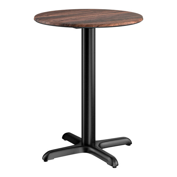 A round standard height table with a textured walnut finish top and a black cross base plate.