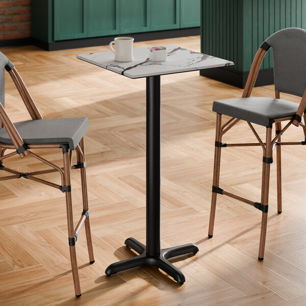 A square bar height table with a smooth Versilla finish and a black cross base plate.