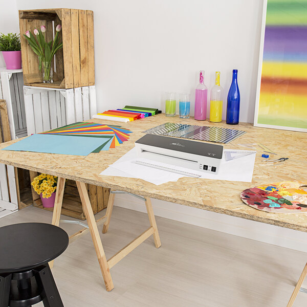 A black round table with a Royal Sovereign laminator on it.