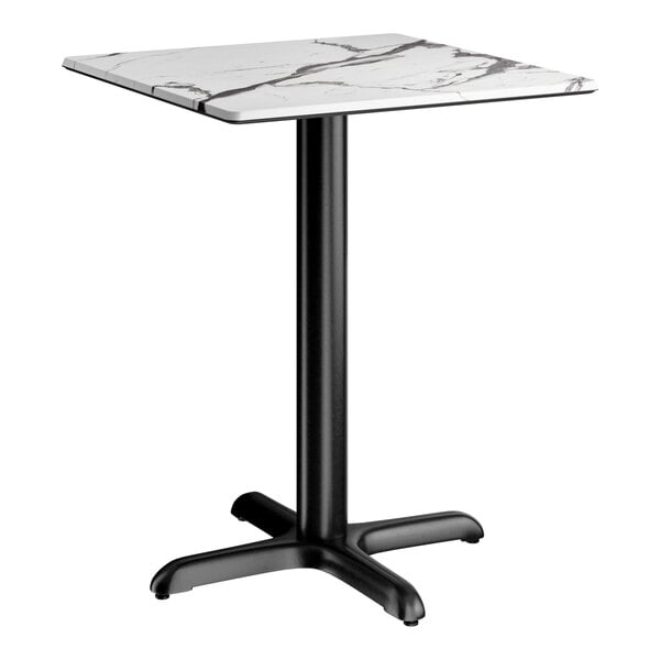 A square standard height table with a smooth white marble-like top and a black cross base plate.