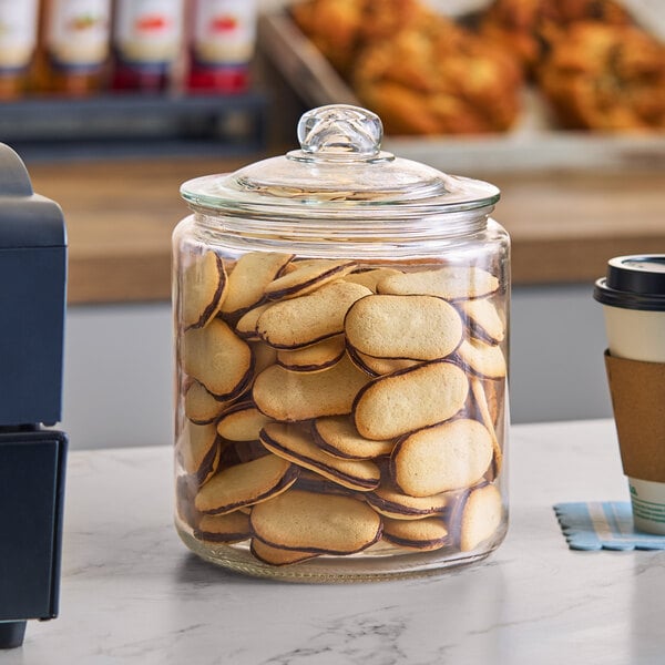 A one-gallon glass jar with a glass lid filled with cookies.