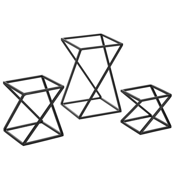 A group of three black metal geometric display risers.