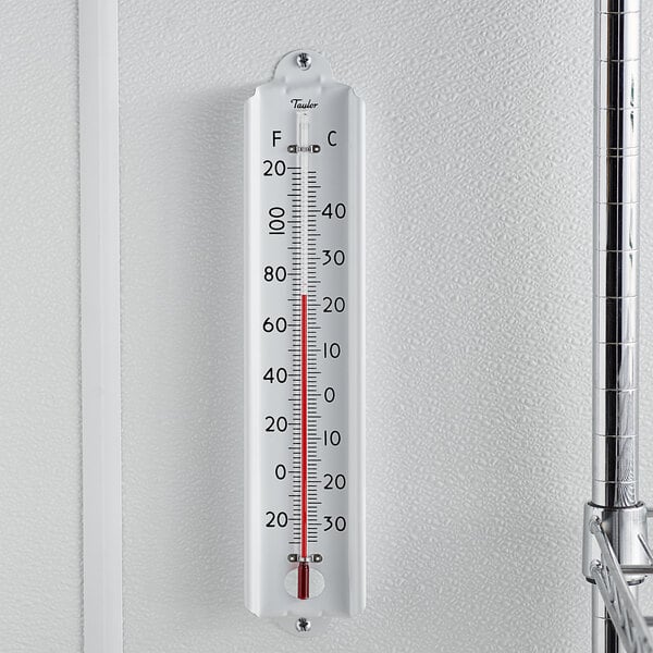 A Taylor dry storage wall thermometer on a white wall.