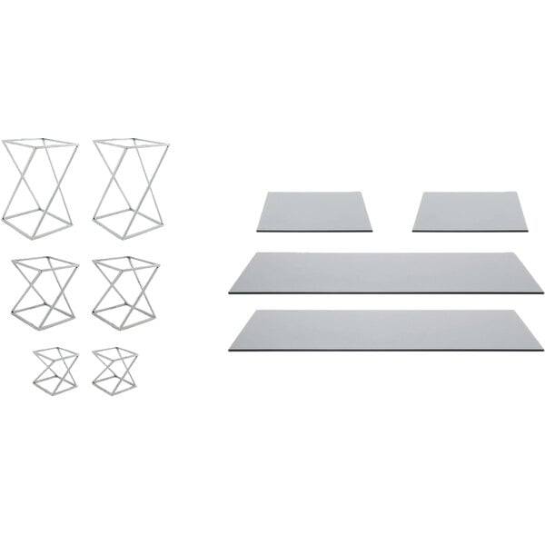 A group of metal geometric display risers with smoke glass boards on a table.