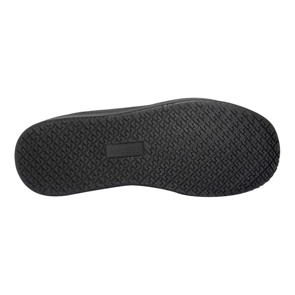 The image shows the black rubber outsole of a shoe with a textured, slip-resistant tread pattern.