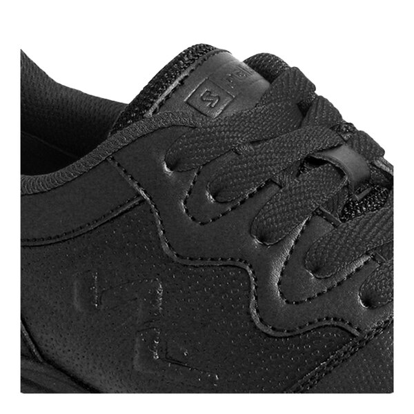A close-up view of a black athletic shoe with textured material, visible stitching, and black laces.