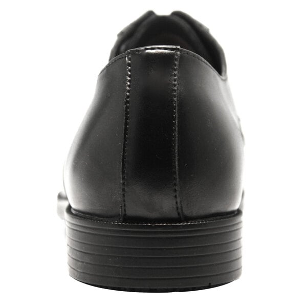 A close-up of the bottom of a Genuine Grip black leather oxford shoe.