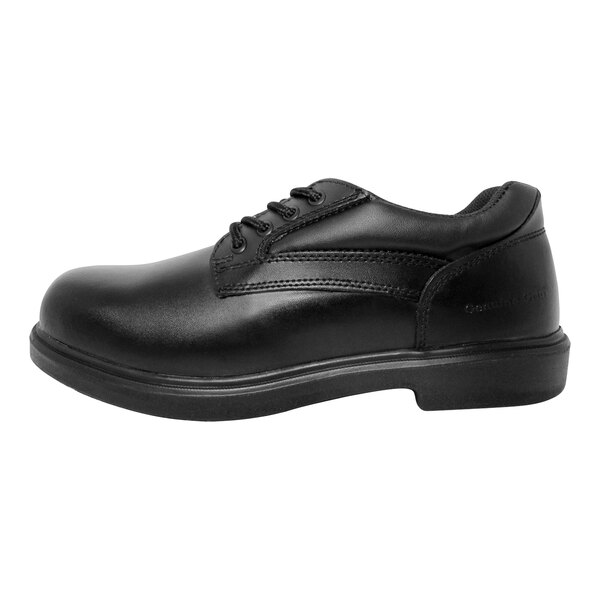 A close-up of a Genuine Grip men's black leather oxford shoe with laces and a rubber sole.